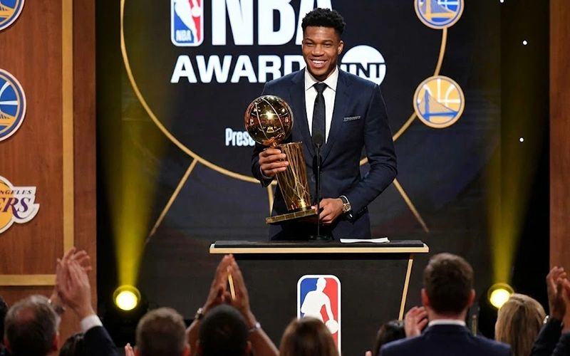 Basketball star player holding MVP award trophy